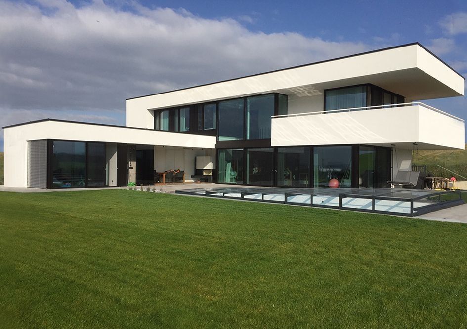Moderne Villa mit großer Glasfassade und weitläufigem Garten