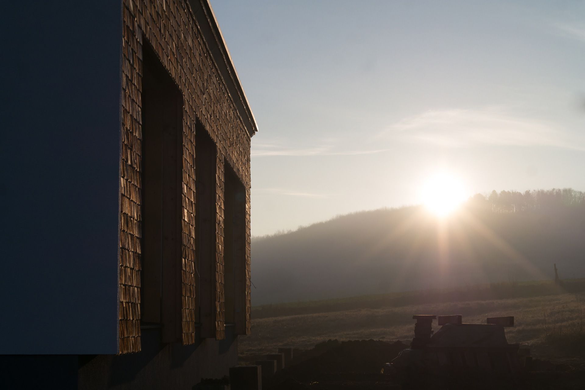 Moderne Holzfassade eines Hauses im Sonnenuntergang am Hang