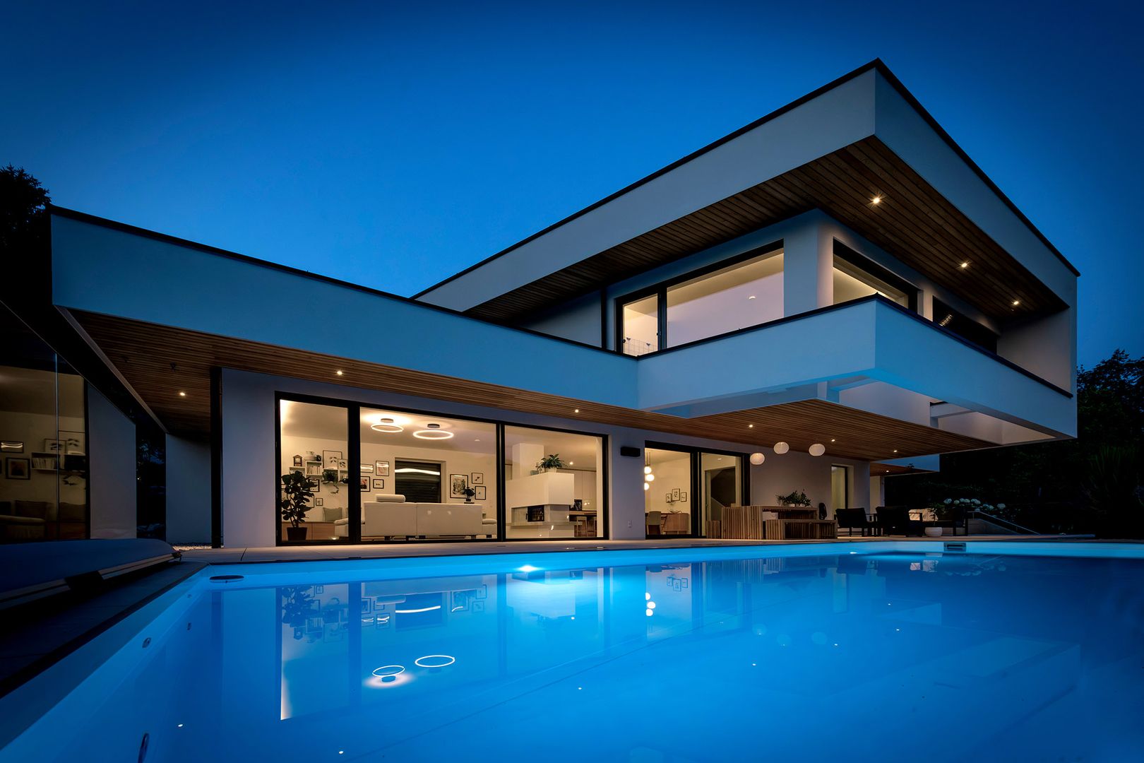 Moderne Villa mit Pool und Glasfront bei Nacht